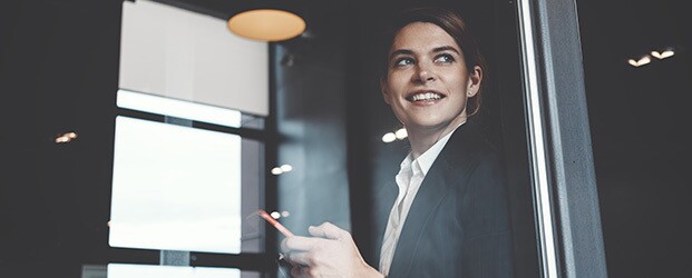 Woman in business attire smiles in a modern office setting