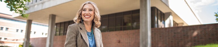 Chico student smiling in front of building on campus