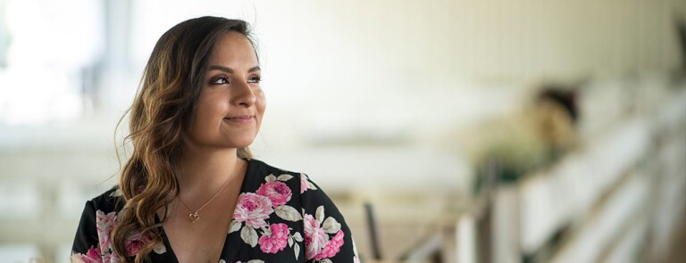 Young female Chico State student wearing floral print dress and smiling