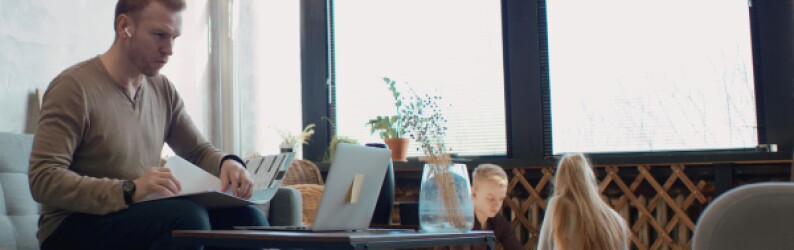 Father works on school work with children in living room