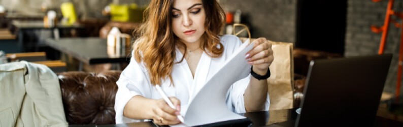 Women Works on Resume in Cafe