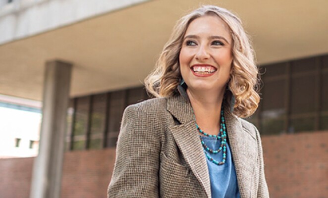 Chico student smiling in front of building on campus
