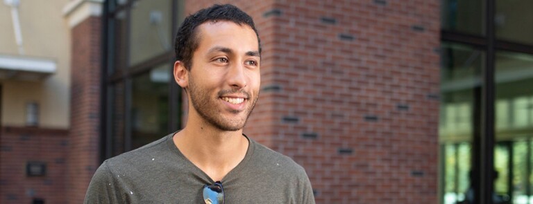 Chico state student smiling in front of building on campus