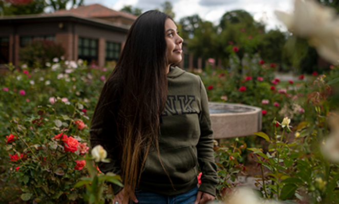 Female Chico State student in campus rose garden
