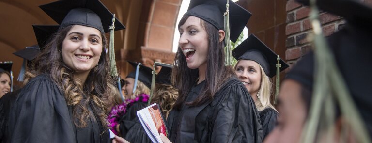 Two graduates smiling